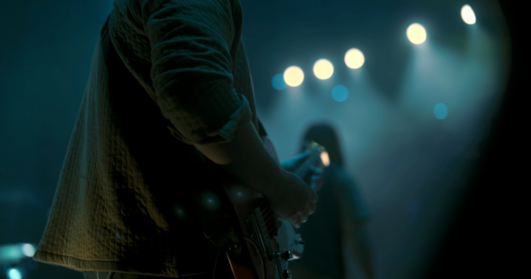 Close-up of a guitarist performing live