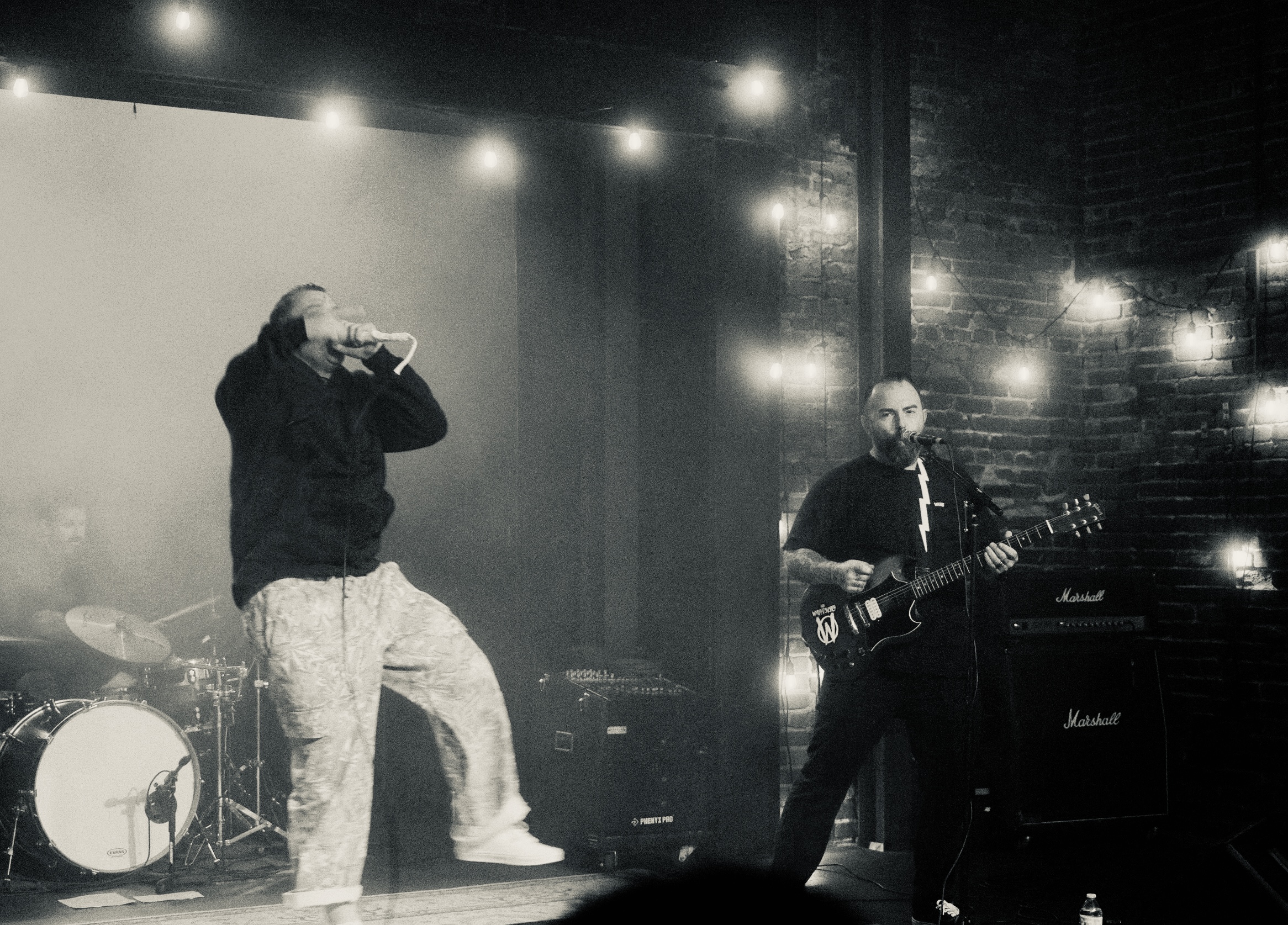 Vocalist and guitarist performing on an intimate club stage